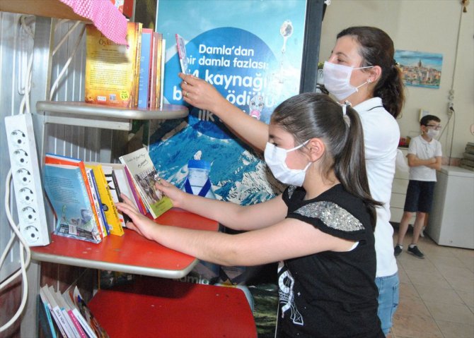 Pastanede kurulan kütüphaneden kitap alan çocuklara dondurma ikramı