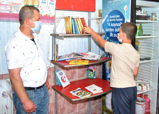 Pastanede kurulan kütüphaneden kitap alan çocuklara dondurma ikramı