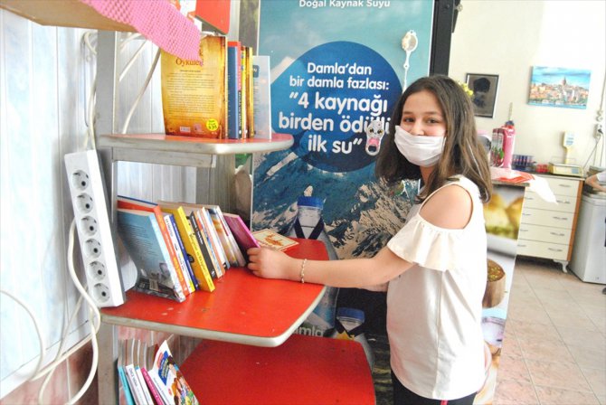 Pastanede kurulan kütüphaneden kitap alan çocuklara dondurma ikramı